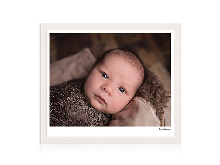 Álbum fotográfico paisagístico com um bebê na capa.