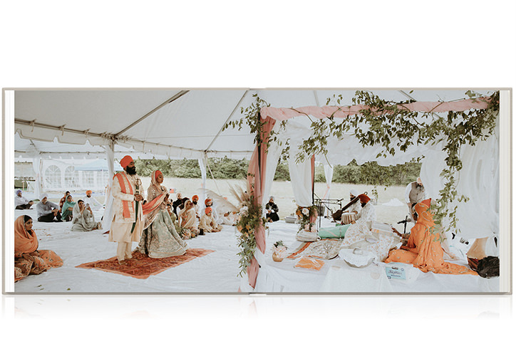 Indian wedding couple at aisle praying in white tent standing on orange carpet