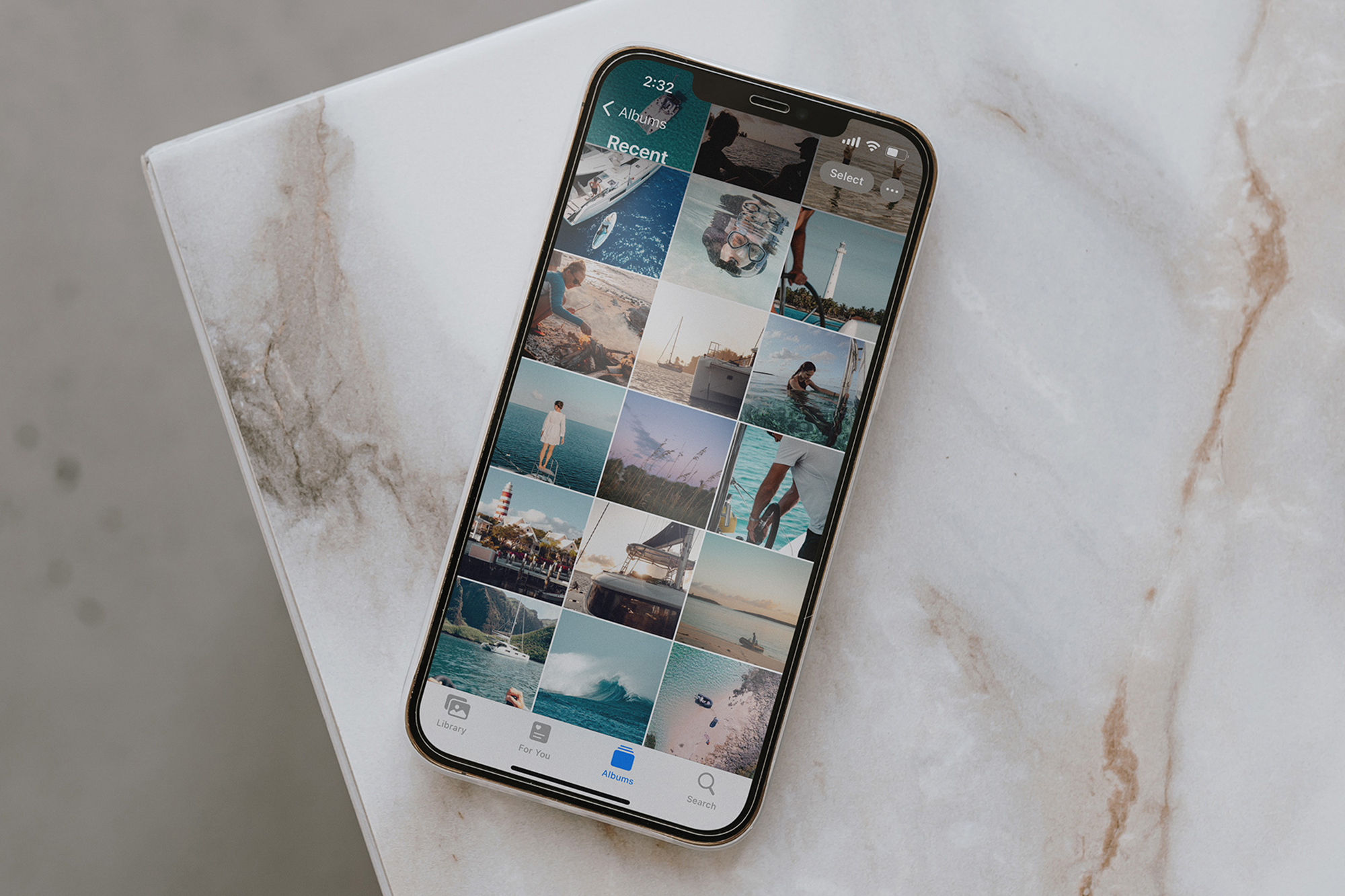 iPhone on counter top with camera roll open showing travel adventure photos