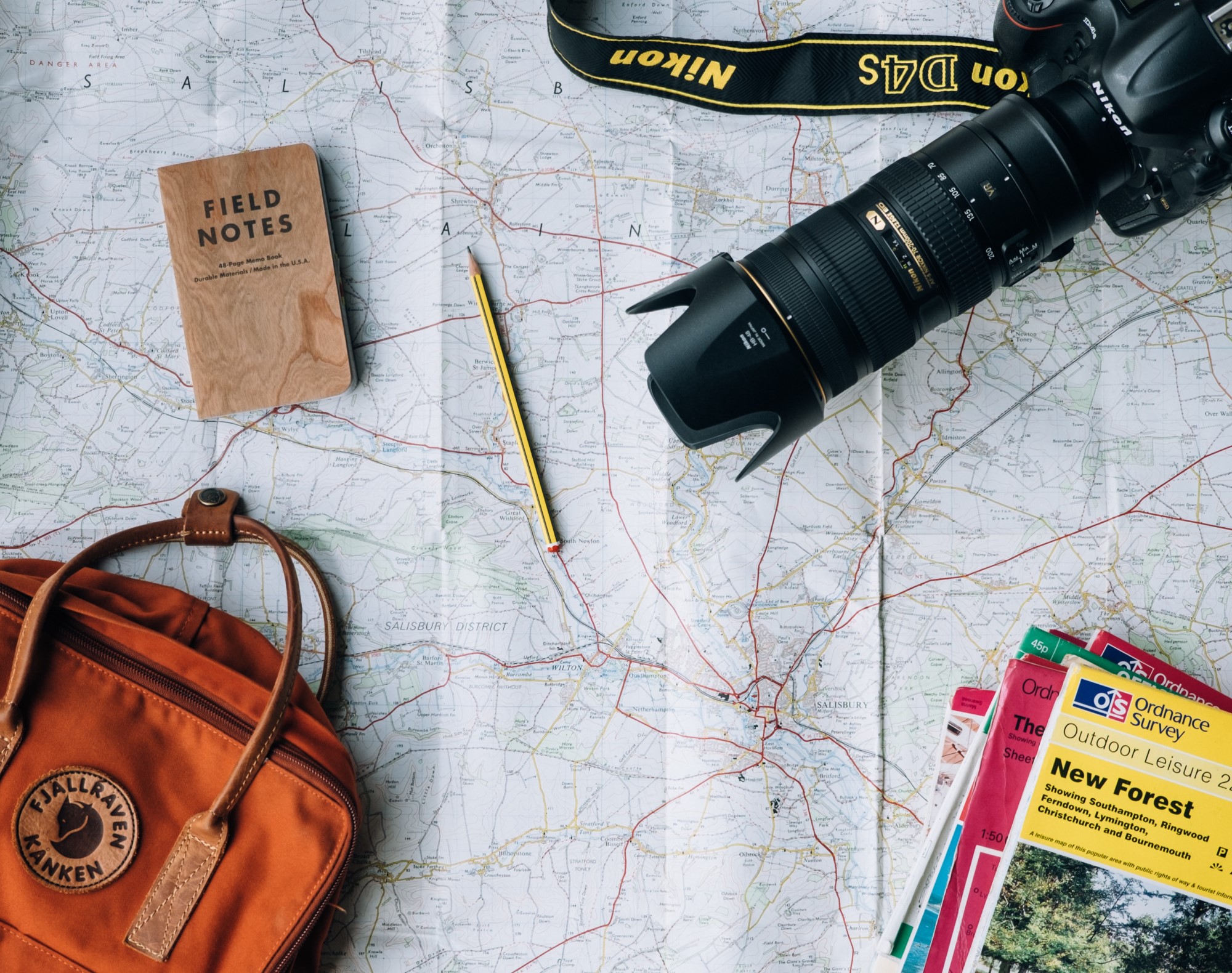 Map laid out with camera, notebook and travel books
