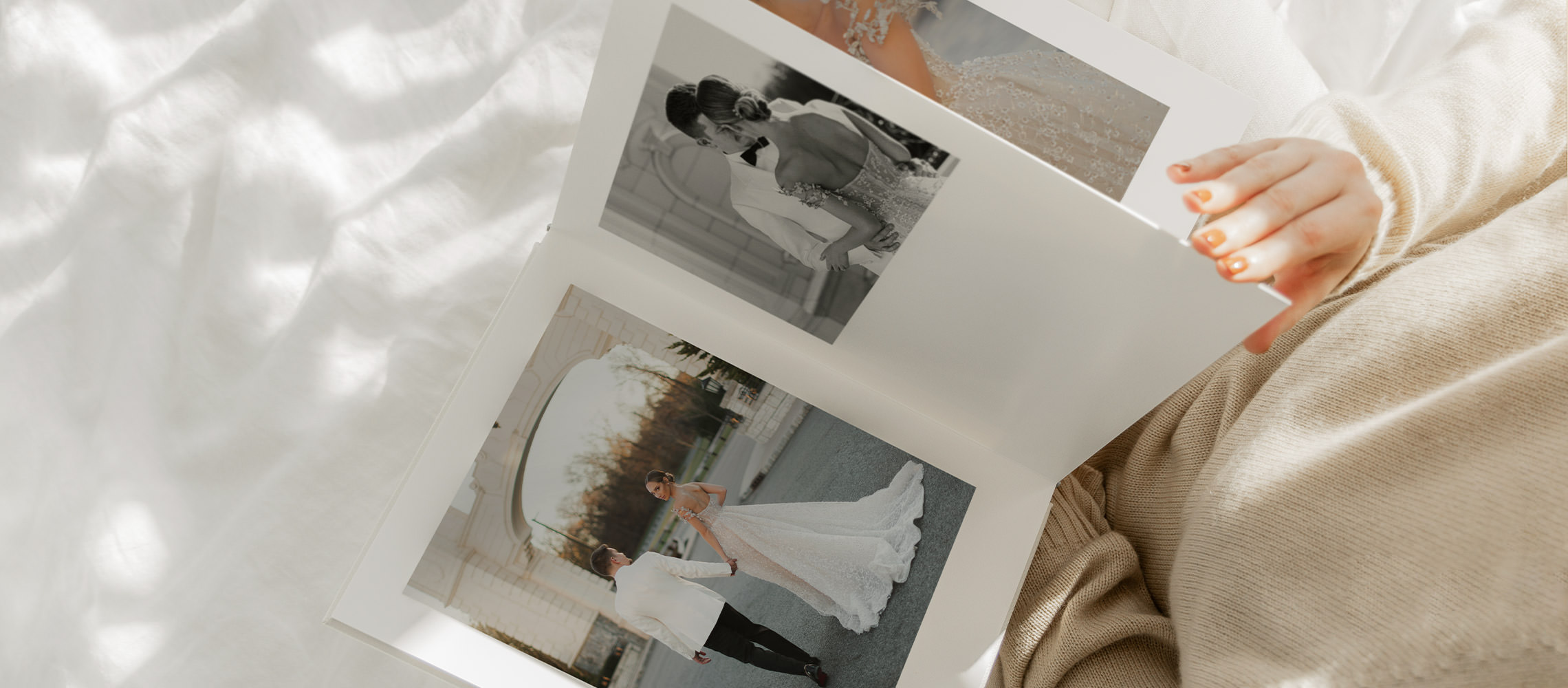 Women holding premium photo album featuring wedding images