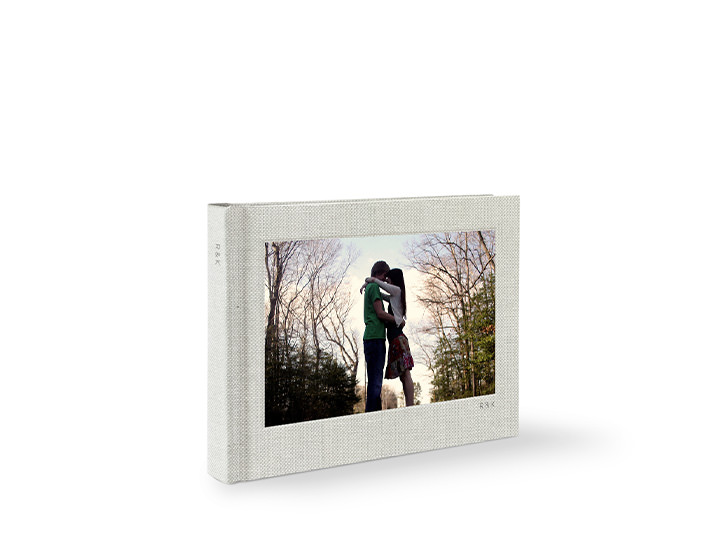Álbum de fotos premium em formato paisagem com casal abraçando na capa.