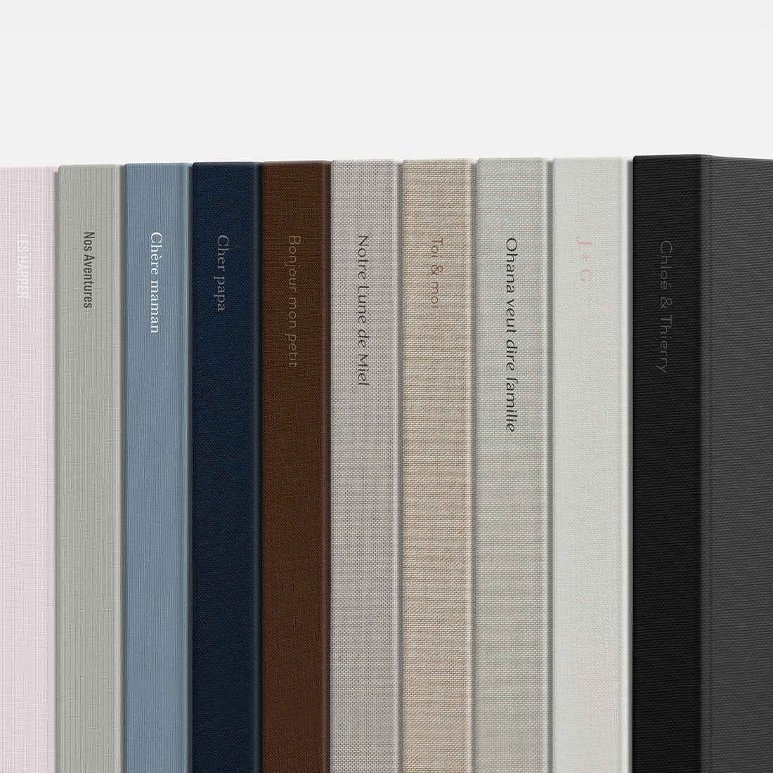 Pile d'albums photo haut de gamme avec différents tissus de couverture.