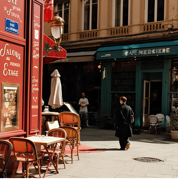 Woman in black walks by a red cafe in Paris France