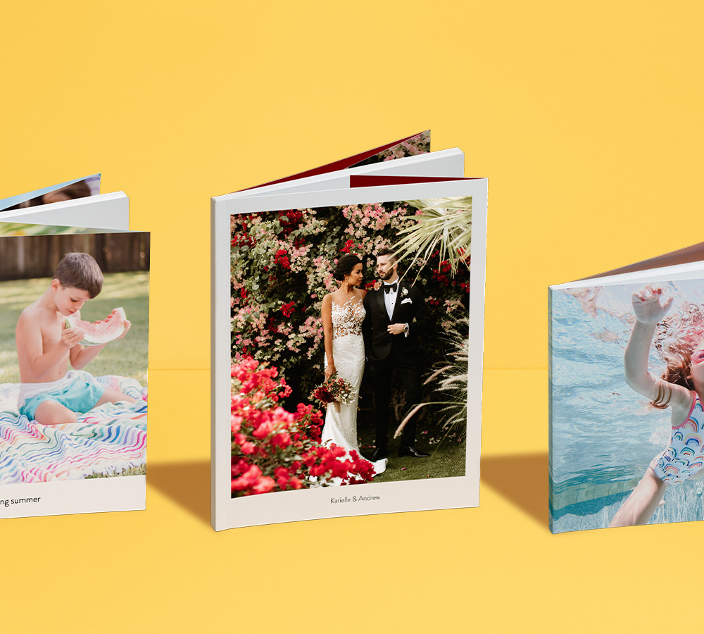 Três álbuns de fotografias de capa mole vertical com diferentes motivos.