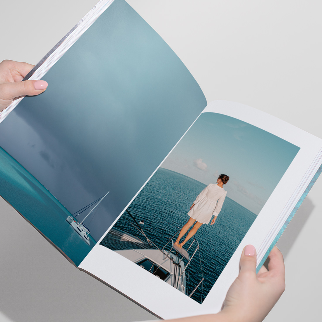 Open Travel Magazine showing spread of travel photos on a boat in ocean